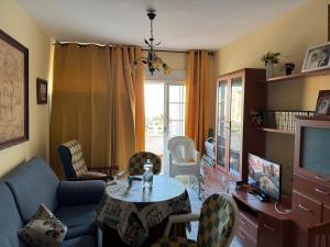 a living room with a table and a tv at Apartamento Torrox5 in Torrox Costa