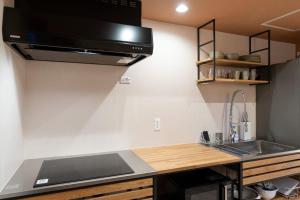 a kitchen with a sink and a stove top oven at RERESO Motohakone in Hakone