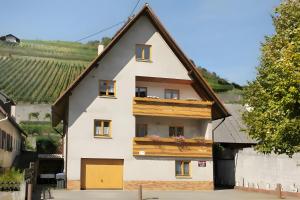 a white house with a gambrel roof at Gästehaus zum Schlossberg in Vogtsburg +13 photos