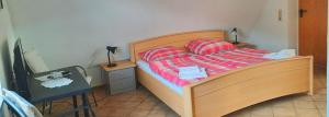 a bedroom with a bed and a desk with a lamp at Gästehaus zum Schlossberg in Vogtsburg