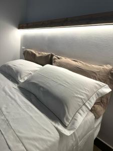 a bed with white sheets and pillows on it at Dimora 21 in Ruffano +8 photos