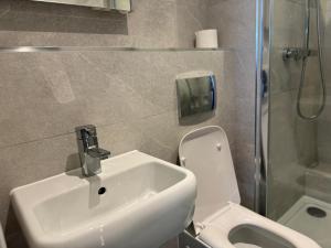 a bathroom with a sink and a toilet and a shower at Bright & Stylish en-suite bedroom suitable for singles, couples, and families in a 2bed apartment in Chatham