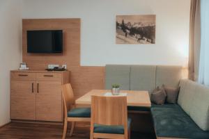 a living room with a table and a couch at Landhotel Gressenbauer in Hinterstoder
