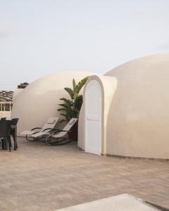 un edificio bianco con una porta bianca e una pianta di Nausicaa Guesthouse a Marsala