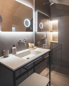 un bagno con un lavandino e un grande specchio di Nausicaa Guesthouse a Marsala