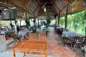 a restaurant with tables and chairs and a wooden table at Hoi An Mountain House Villa in Hoi An