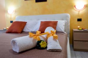 ローマにあるAudrey Roomsのベッドにタオルと花を飾った客室です。