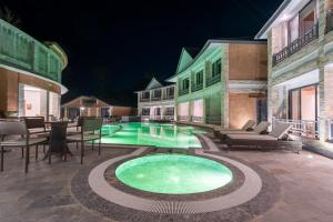 a swimming pool in the middle of a yard at night at Royal Tulip Chitwan Nepal in Sauraha