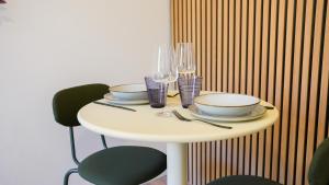 a table with plates and wine glasses on it at Tropical Jungle in Béziers