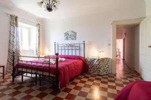 a bedroom with a bed with a red comforter at Dimora Storica Dei Nelson in Maniace