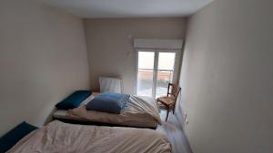 a small bedroom with a bed and a window at Maison de village in Corbonod +2 photos