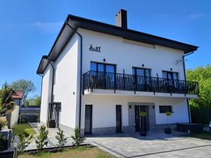 a white house with a balcony at Pokoje gościnne Lenka-deptak in Ciechocinek