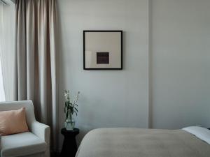 a bedroom with a bed and a chair and a picture at 大理栖子山房森氧度假民宿 in Dali