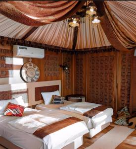 a bedroom with two beds in a tent at Regency Wadi Rum in Wadi Rum