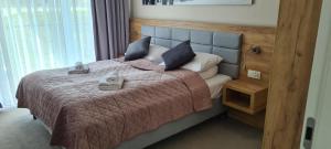 a bedroom with a bed with a purple blanket and pillows at Aparthotel Apartamenty Czarna Góra 134 in Sienna