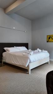 a bedroom with a white bed with white sheets at Amelié Lago d’Orta Hotel in Omegna