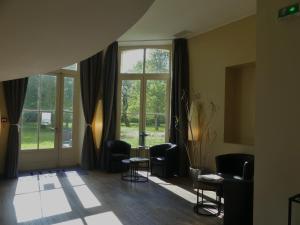 a living room with chairs and a large window at Hôtel et SPA du Château in Lagord