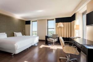 a hotel room with a bed and a desk and a computer at NH Den Haag in The Hague