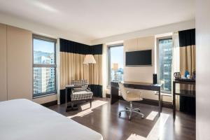 a hotel room with a bed and a desk and a chair at NH Den Haag in The Hague