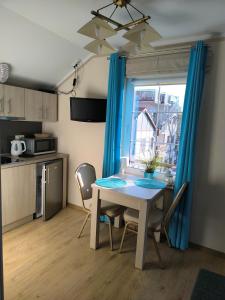 a table and chairs in a kitchen with a window at Apartamenty Turkusowe in Rowy