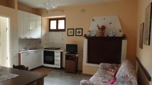 a living room with a couch and a kitchen at Il CORTILETTO in Acquaseria