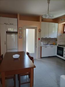 a kitchen with a wooden table and a dining room at Il CORTILETTO in Acquaseria