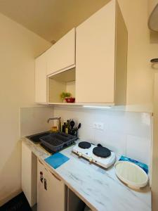 Una cocina con gabinetes blancos y encimera. en Studio entre Issy et Pte de Versailles, en Issy-les-Moulineaux