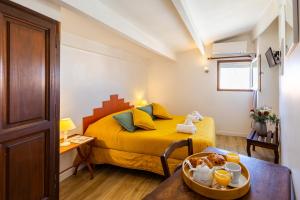 a small bedroom with a yellow bed and a table at Le Fangassier in Saintes-Maries-de-la-Mer