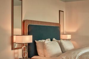 1 dormitorio con 2 lámparas y 1 cama con almohadas en Hotel Klubben, en Tønsberg