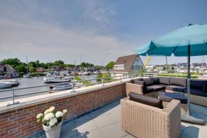 a patio with couches and an umbrella and a harbor at Kaag Resort in Warmond