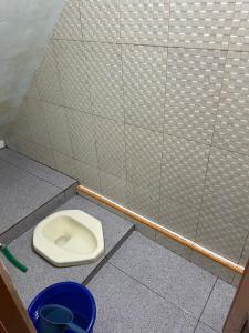 a bathroom stall with a toilet in the floor at Homestay Lingga Yoni DIENG in Banjarnegara +4 photos
