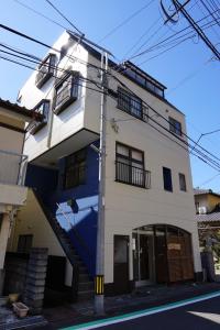 ein weißes Gebäude mit einer blauen Treppe darauf in der Unterkunft Okusuruga Guest House - Vacation STAY 14698 in Numazu