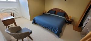 una camera da letto con un letto, una sedia e una scrivania di Omaha beach vue les Braves a Saint-Laurent-sur-Mer