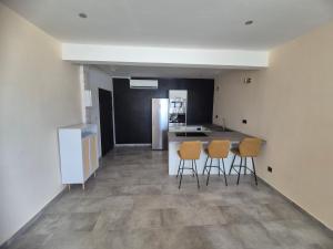MamoudzouSplendide T2 Meublé à Mtsapéré Baobab vue sur Mer的一间厨房,内设三把椅子和一个柜台