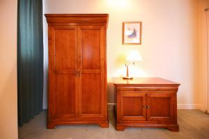 a bedroom with a wooden cabinet and a lamp on a table at Hotel Marital Sousei Kurume in Kurume