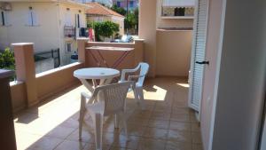 a small balcony with a table and chairs on it at Βlue Horizon Lixouri in Lixouri
