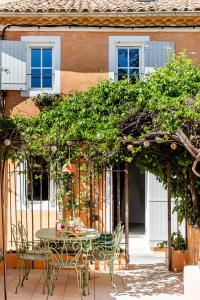 un patio con mesa y sillas bajo una pérgola en Chez Fanny, en Bédoin