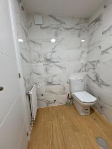 a white bathroom with a toilet and marble walls at La Glicinia VUT-7355-AS in Cangas de Onís +18 photos