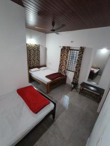 a room with a bed and a couch and a table at Aqueduct Retreat in Kushālnagar