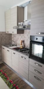 een keuken met witte kasten en een fornuis bij Melograno2 in Torre San Giovanni Ugento +12 foto's