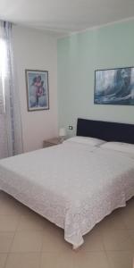 een slaapkamer met een groot wit bed in een kamer bij Melograno2 in Torre San Giovanni Ugento