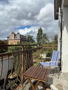 a wooden deck with a chair on a balcony at Les Trente Glorieuses in Épône