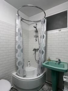 a bathroom with a tub and a sink and a shower at Les Trente Glorieuses in Épône