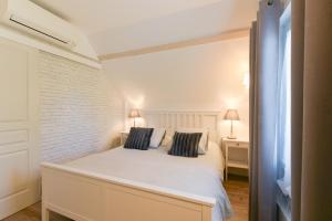 una camera con un letto bianco con due cuscini di Gite Cottage de la Douloustre a Montgaillard