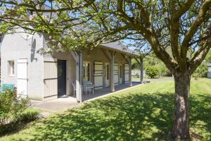 a house with a tree in the yard at Gite Cottage de la Douloustre in Montgaillard