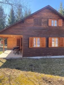 a wooden house with a picnic table in front of it at Ivói Faház in Izvoare