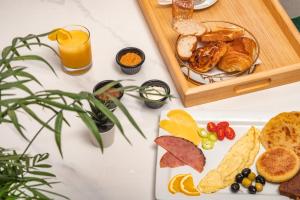 a white table with a tray of bread and orange juice at Maarif elite suites in Casablanca