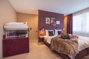 a bedroom with a large bed and a large window at Boutique Hotel Am Park in Valdaora