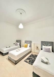 una habitación con dos camas y un sofá en Sara Apartment Parking free, en Chefchaouen