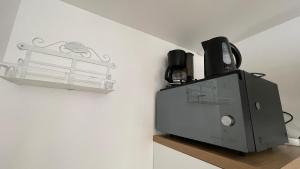 a toaster sitting on a shelf next to a wall at Paco Homestay in Saint-Germain-sur-Morin